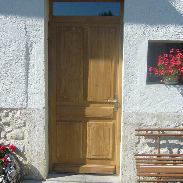 Porte d’entrée en chêne à panneaux table saillante.